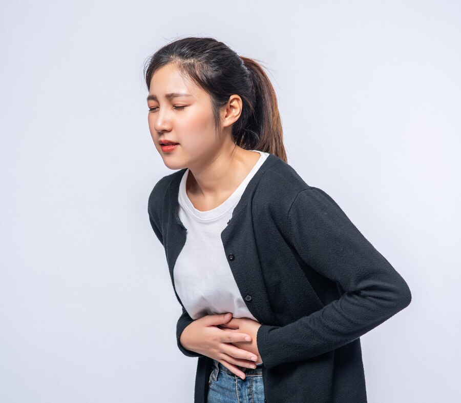 woman standing with stomach ache presses her hand her stomach 1150 25976